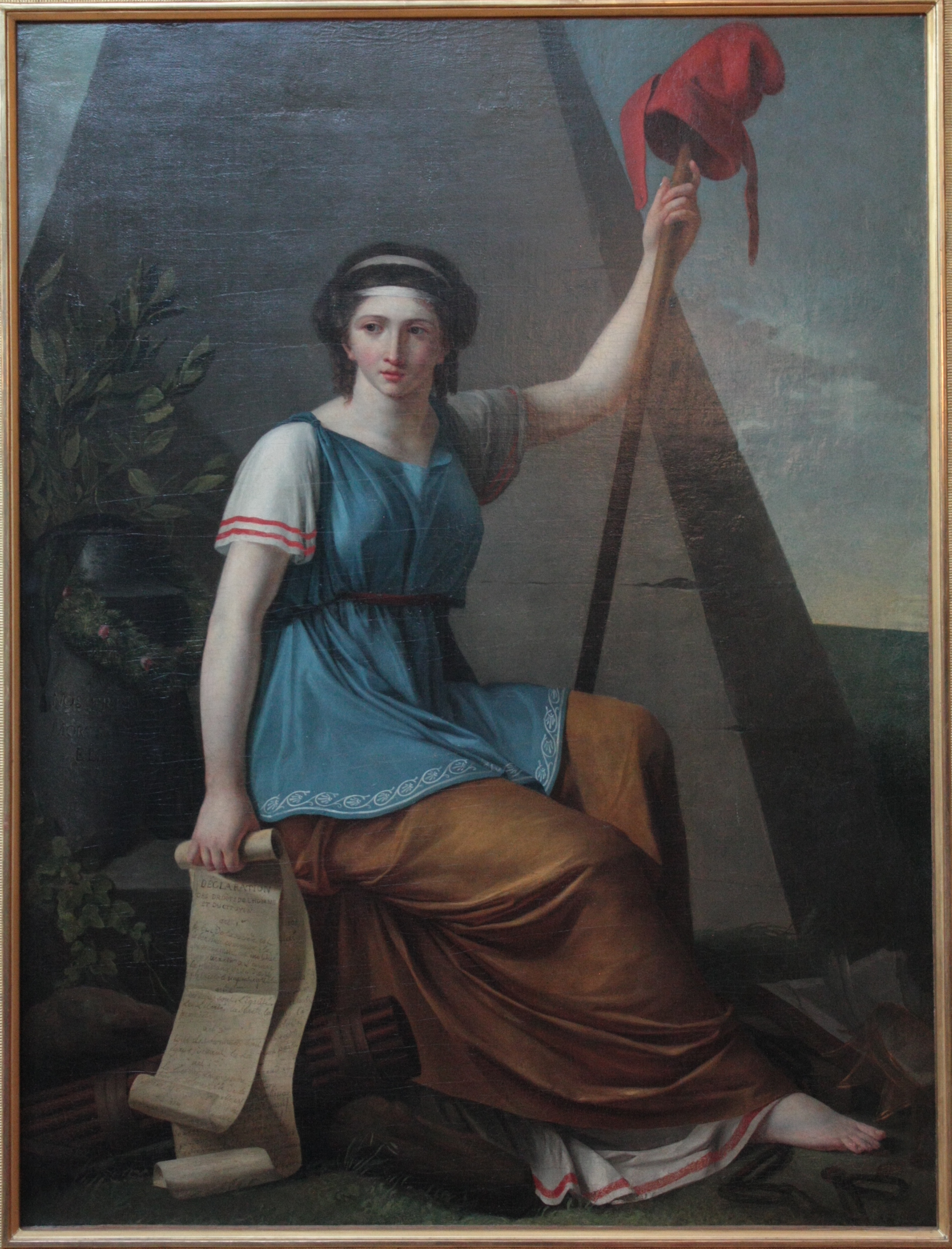 An allegorical painting of Liberty as a seated woman holding a pike topped with a liberty cap, beside a broken chain.